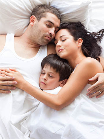 Family cuddling in bed
