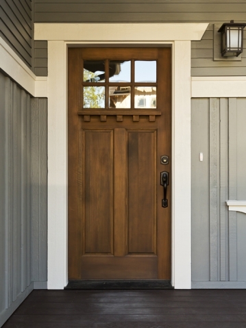 Dark wooden front door from inside a home 